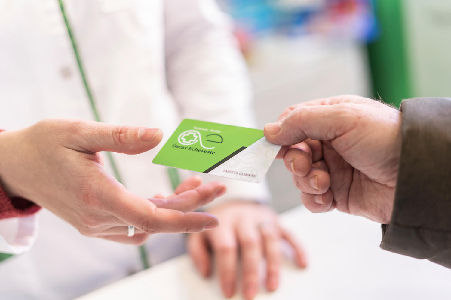 Cliente pasando la tarjeta cliente a farmacéutica