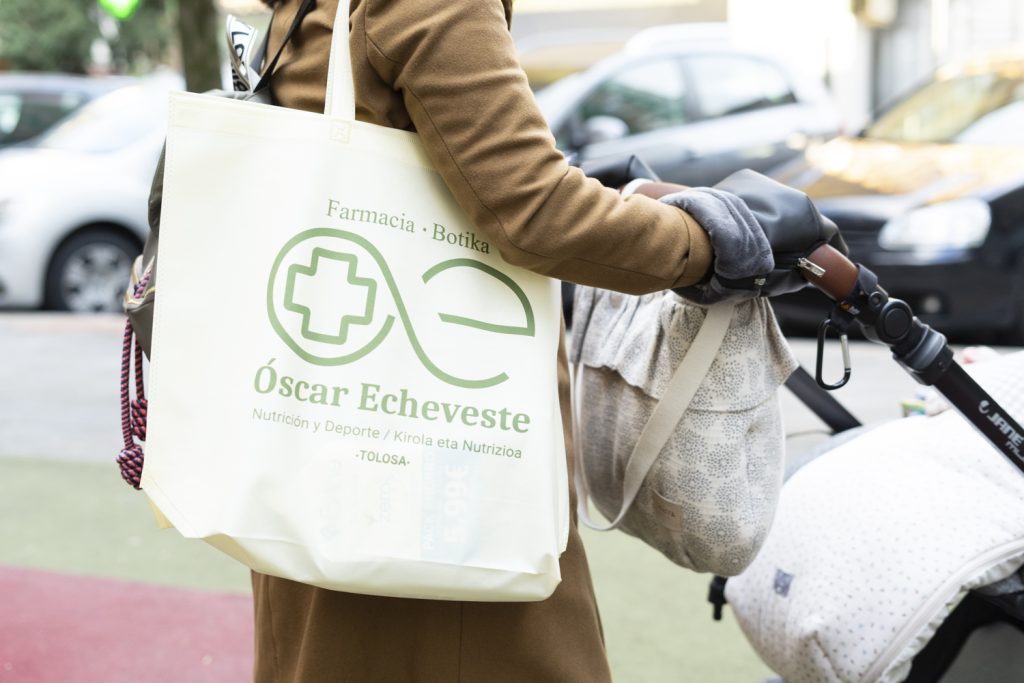 Persona portando totebag con publicidad de la farmacia